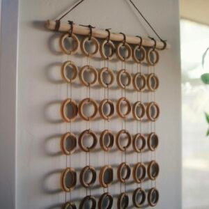 A rustic boho wall hanging made of wooden rings, perfect for minimalist decor.