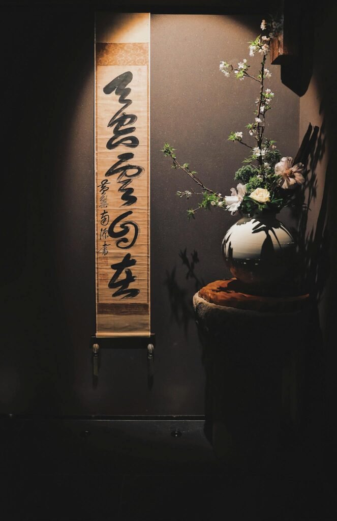 Serene indoor scene featuring a calligraphy scroll and floral arrangement, perfect for tranquil settings.