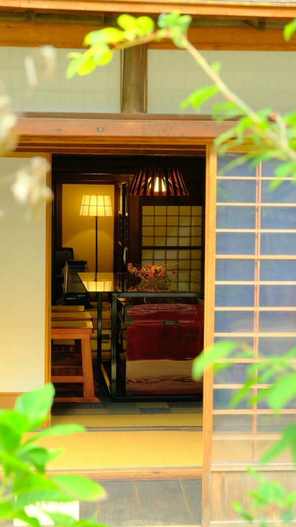 View into a traditional Japanese room through a wooden entrance, featuring shoji screens.