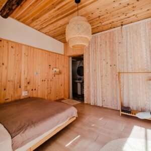 Warm and inviting wooden bedroom interior with natural lighting and minimalist decor.