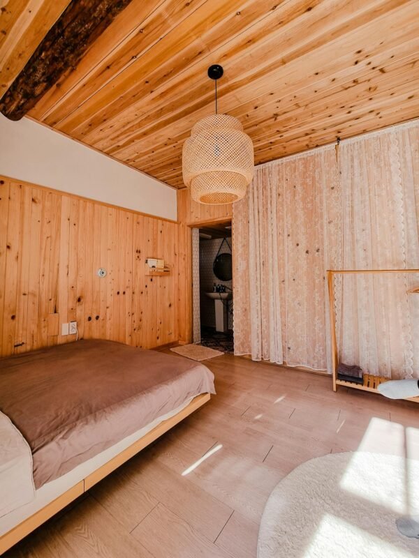 Warm and inviting wooden bedroom interior with natural lighting and minimalist decor.